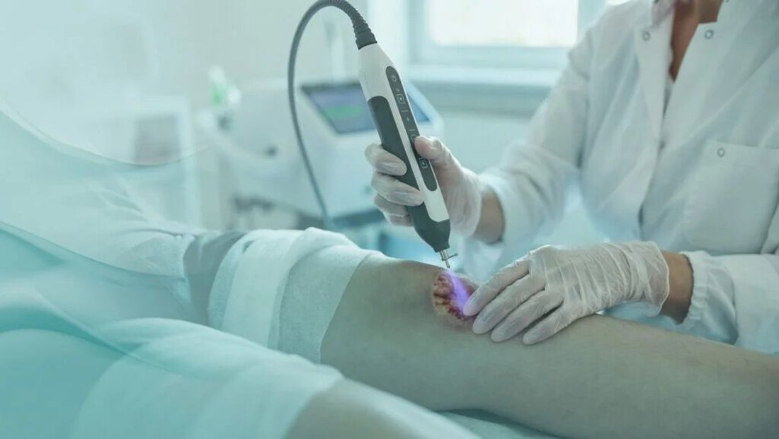 Medicinska sestra previja potkoljenicu bolesnika u ambulanti.
