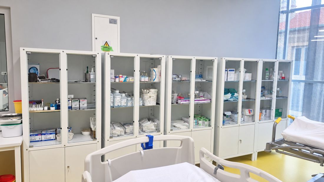 Staklene ormarice s uredno složenim medicinskim priborom i potrošnim materijalom iznad bolničkih kreveta